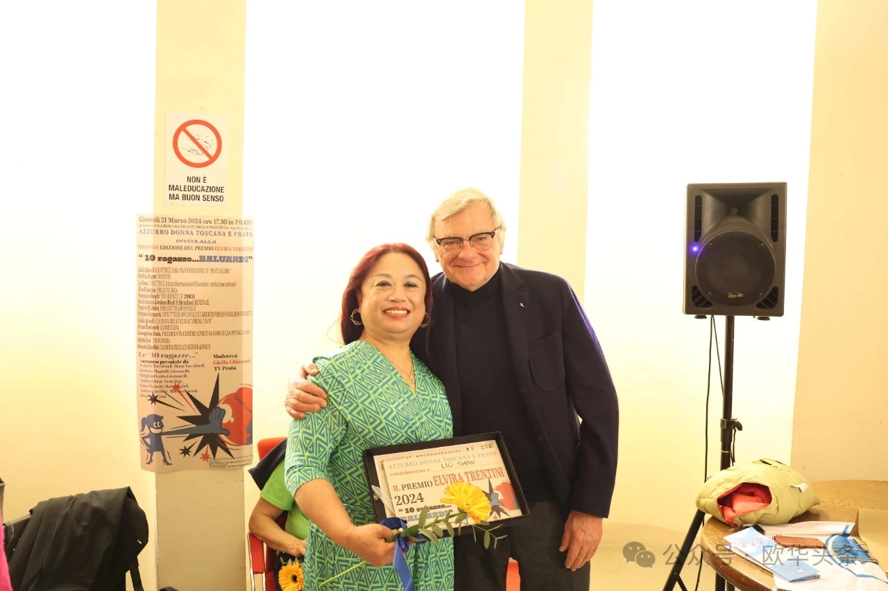 Liu Shan sorride accanto a un uomo con un premio alla cerimonia di Prato